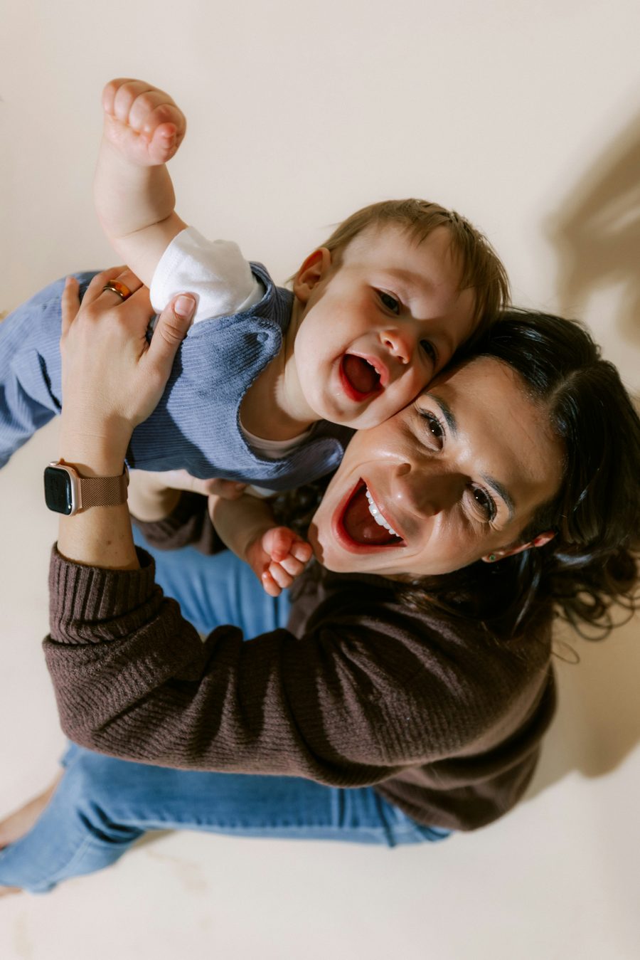 Une maman soulève son bébé qui éclate de rire.